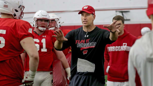 Offensive line coach Bob Bostad works with his players the during the University of Wisconsin spring football practice at Camp Randall Stadium in Madison on Thursday.